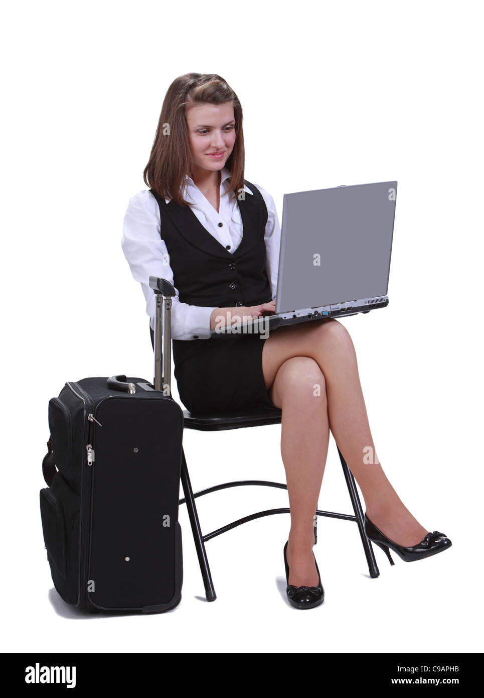 Junge Frau Reisenden in Eile auf dem Laptop neben ihrem Koffer-vor einem weißen Hintergrund isoliert arbeiten. Stockfoto