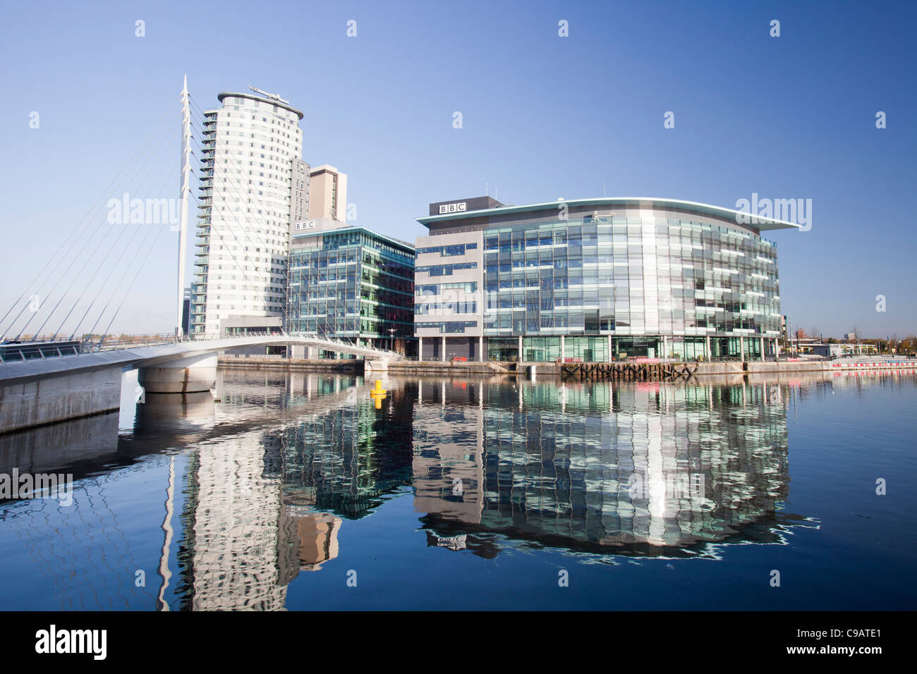 Media City die Heimat der BBC im Norden am Salford Quays, Manchester, UK, reflektiert in den Manchester Ship Canal. Stockfoto