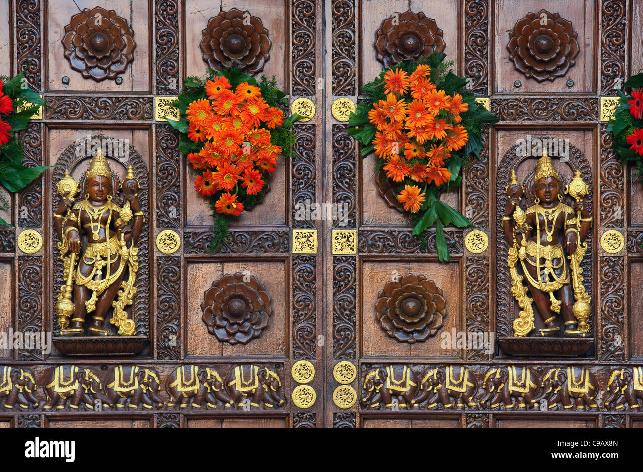 Sathya Sai Baba Ashram, gestaltet aus Holz geschnitzte gopuram Tore. Puttaparthi, Andhra Pradesh, Indien Stockfoto