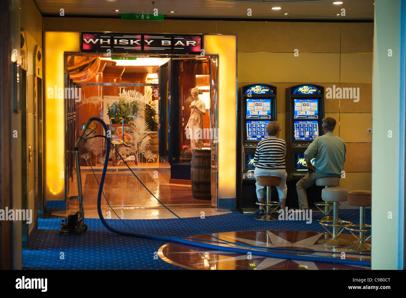 Ein paar spielen Spielautomaten neben einem Staubsauger auf dem Kreuzfahrtschiff birka Paradise Casino Stockfoto