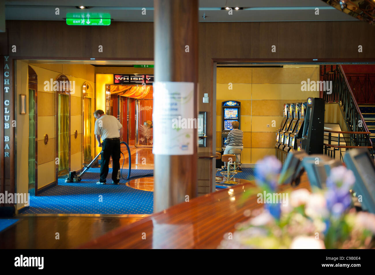 Frau, die eine Spielautomat zu spielen, wie ein Staubsauger den Teppich auf der Kreuzfahrt saugt Schiff Birka Paradise casino Stockfoto