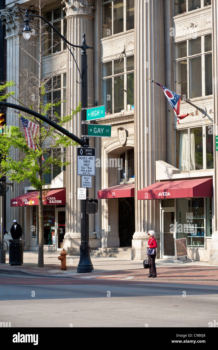 Ältere Frau wartet am Schnittpunkt der High Street und Gay Street in der Innenstadt von Columbus, Ohio. Stockfoto