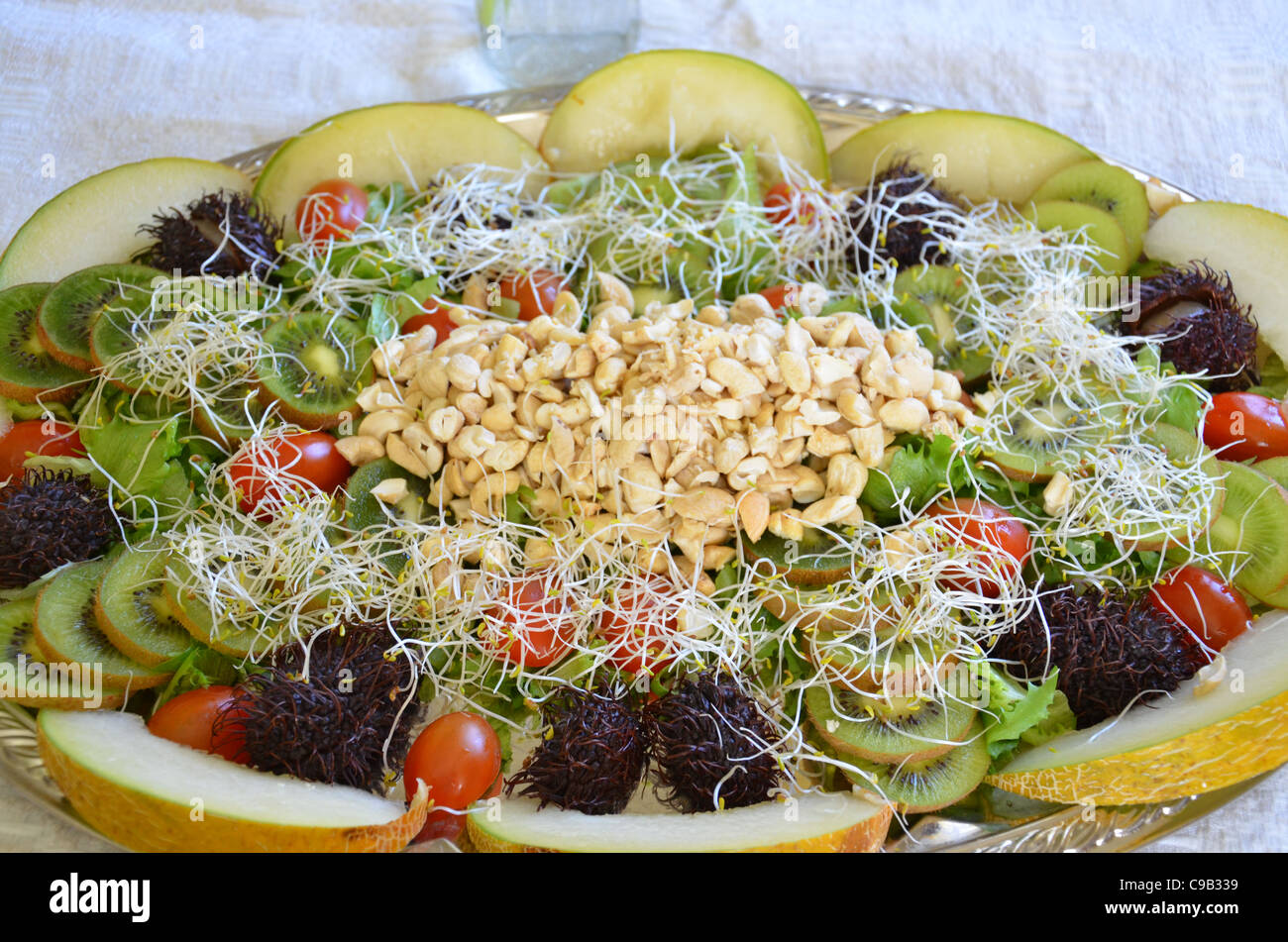 Salat mit Gurken, Obst, Melone, Nüssen, Tomaten... Stockfoto
