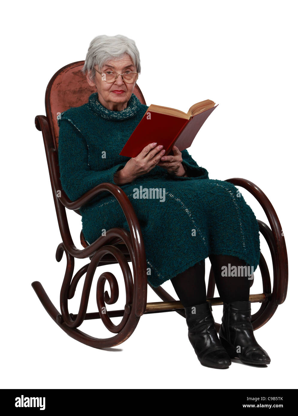 Alte Frau mit einem roten Buch in einer Wippe sitzen und Blick in die Kamera, vor einem weißen Hintergrund isoliert. Stockfoto