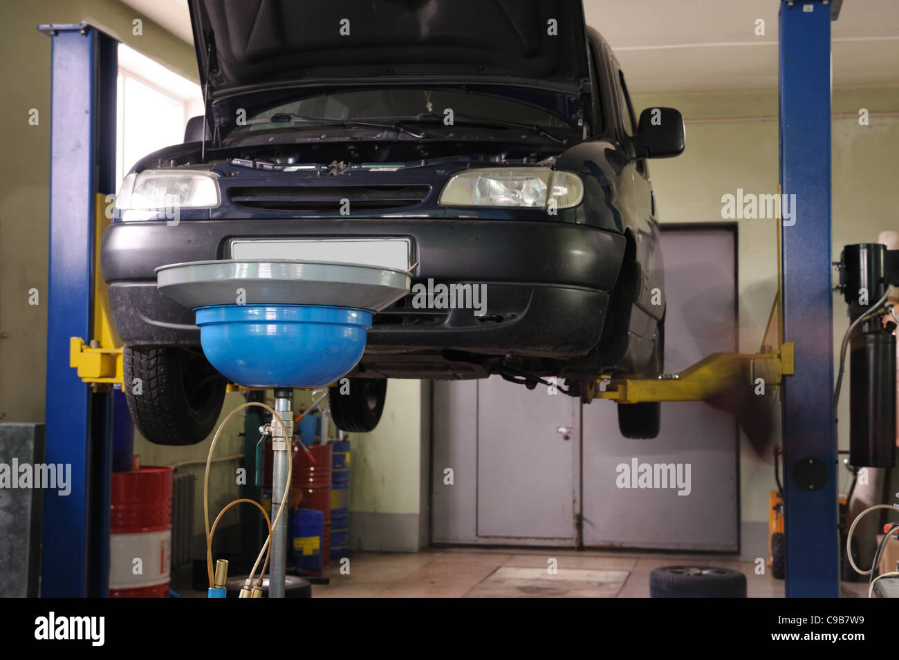 Auto-Service. Das Auto hob auf den Lift und eine Schüssel für Ölwechsel Stockfoto