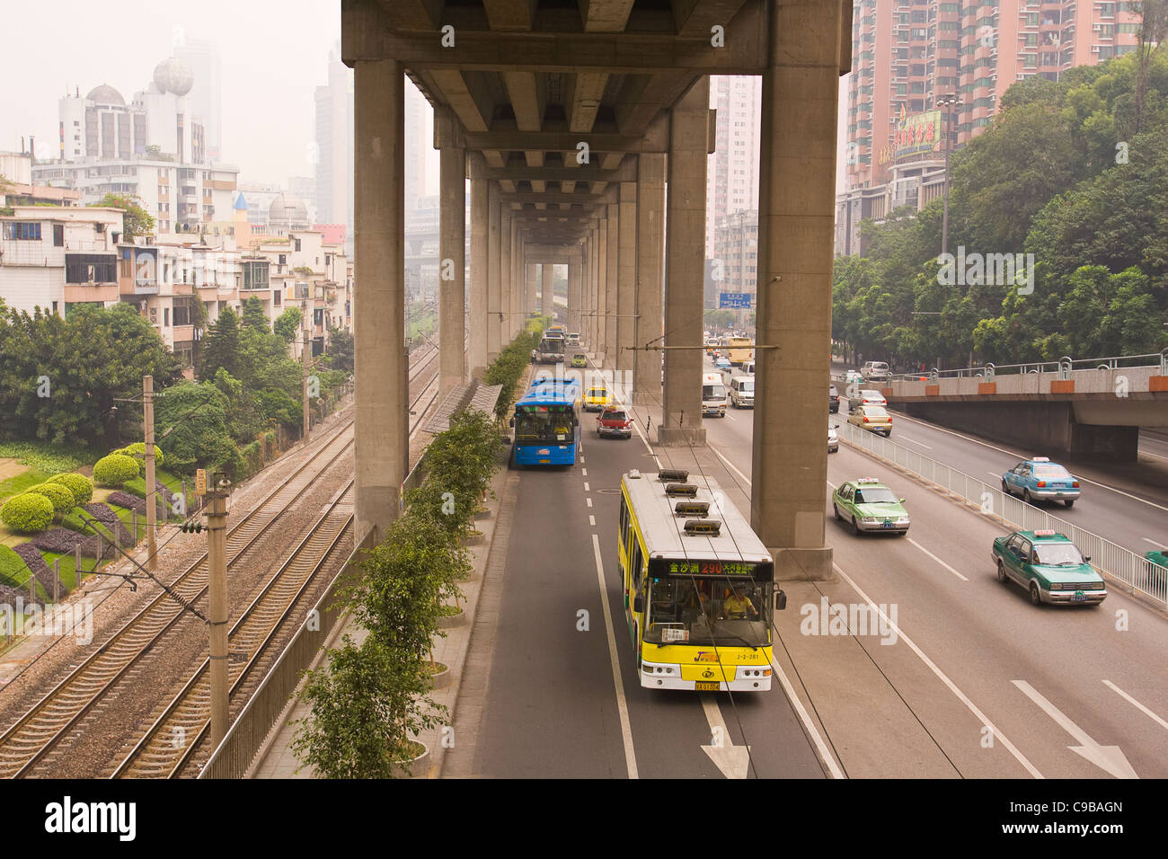GUANGZHOU, Provinz GUANGDONG, CHINA - Busse und Autos auf der Straße unter der Hochstraße, in der Stadt Guangzhou. Stockfoto
