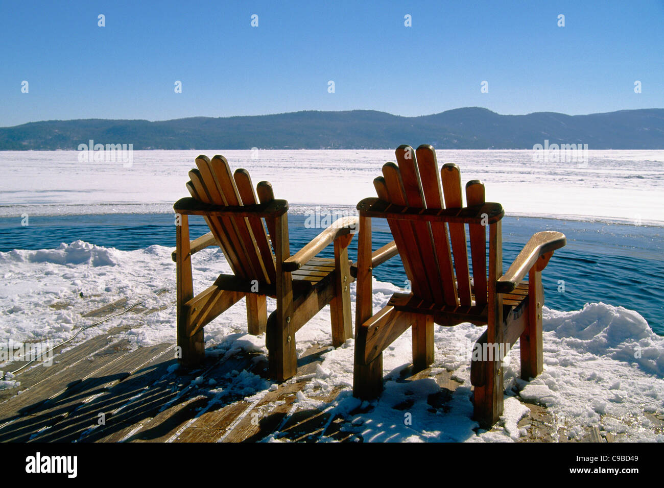Zwei Adirondack Stühle auf einem Deck im Winter, Lake George, New York Stockfoto