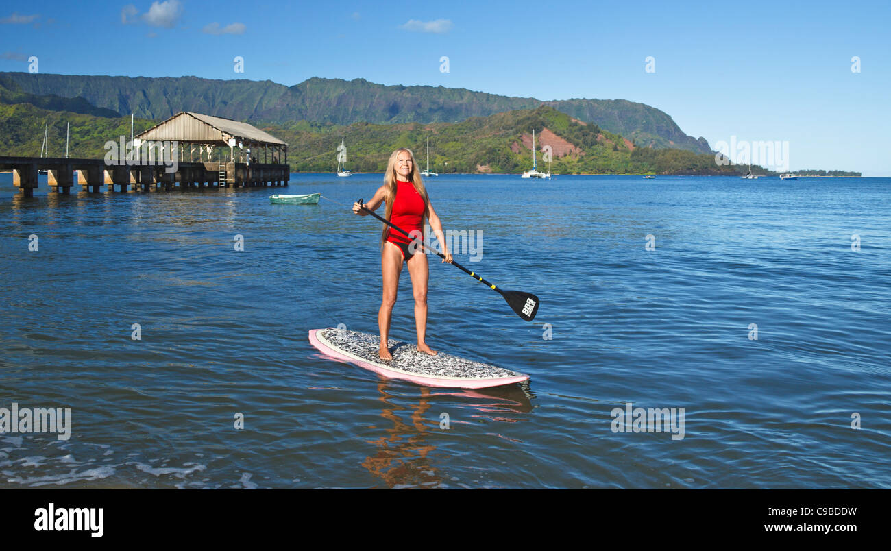 Paddleboarder in Hanalei Bay auf Kauai mit Hanalei Pier und den Mt. Makana genannt Bali Hai, im Hintergrund Stockfoto