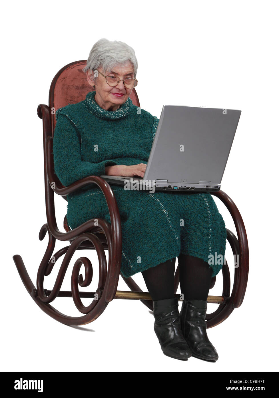 Bild einer älteren Frau mit einem Laptop sitzend in einer Wippe. Stockfoto