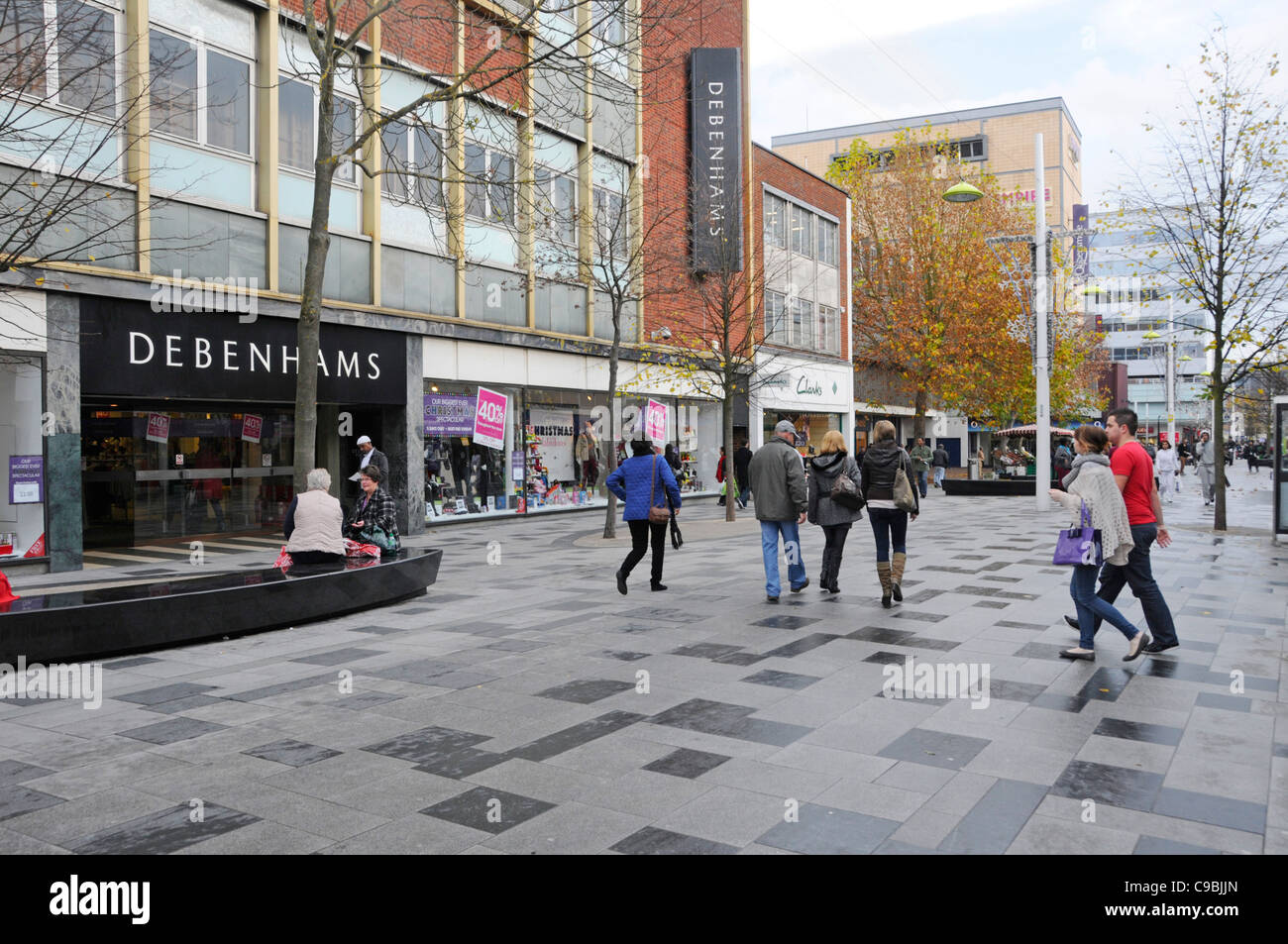 Bäume im Herbst town centre street Szene Leute einkaufen im Einzelhandel High Street Debenhams Department Store Eingang & Fenster angezeigt, Slough Berkshire GROSSBRITANNIEN Stockfoto