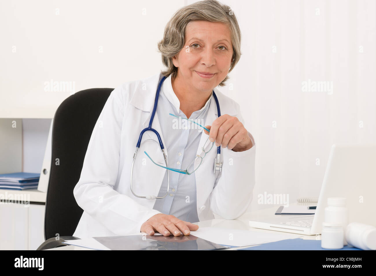 Arztpraxis - Leitende Ärztin arbeiten Computer sitzen hinter der Rezeption Stockfoto