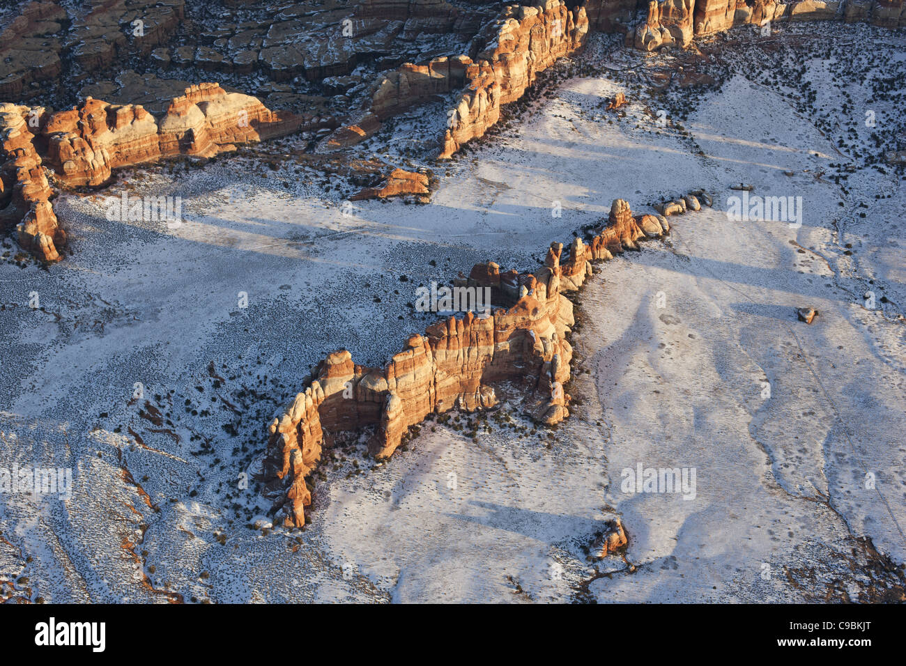 LUFTAUFNAHME. Sandsteinausbisse in einem verschneiten Feld. Der Nationalpark Canyonlands, San Juan County, Utah, USA. Stockfoto