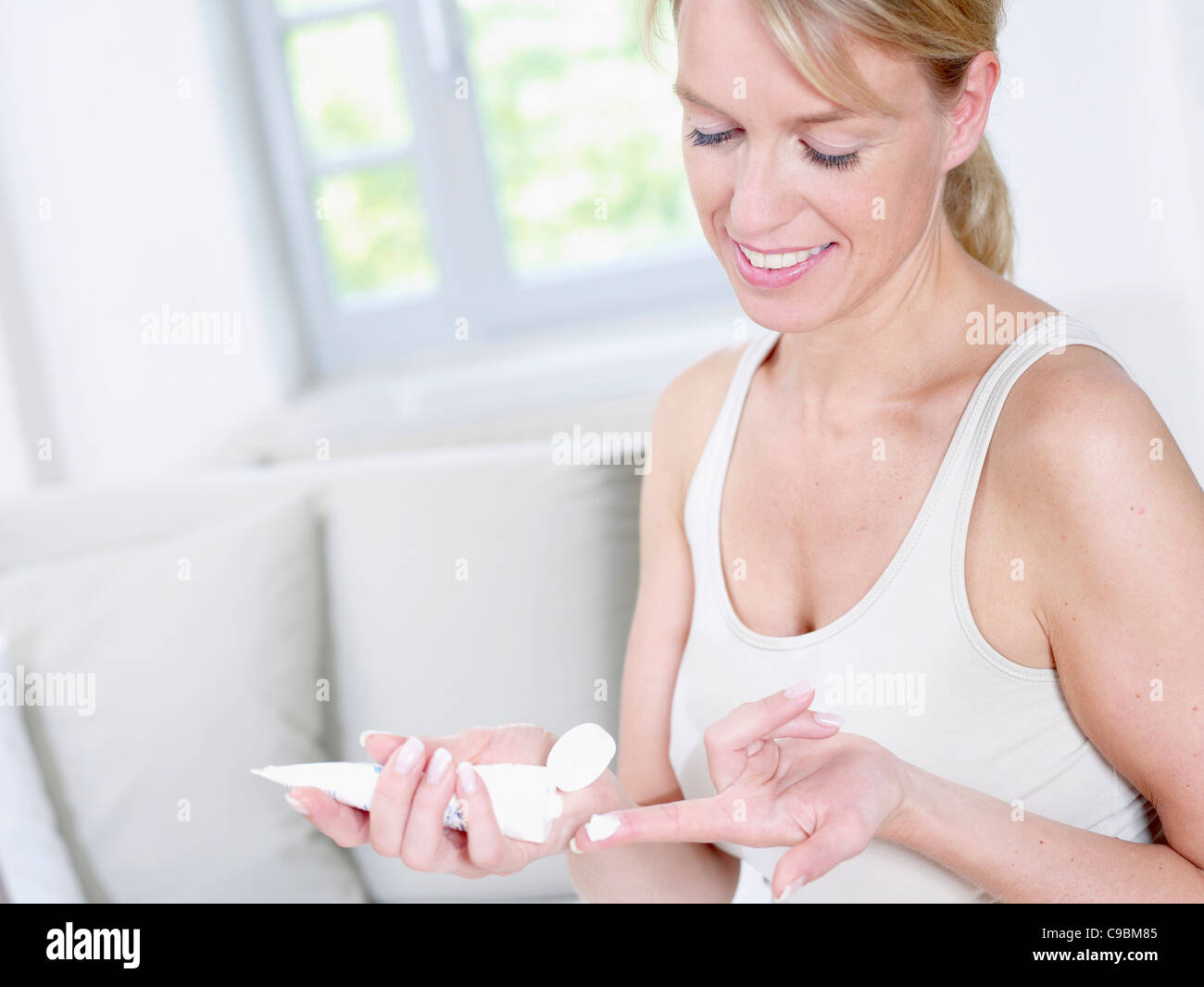 Reife Frau mit Creme Tube, Lächeln Stockfotografie - Alamy