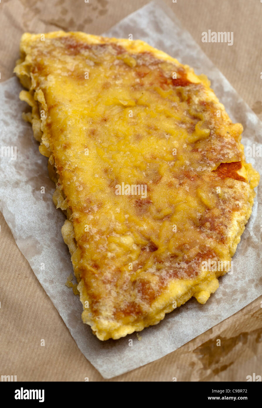 Deep Fried Pizza Glasgow Scotland - ein Beispiel für die seltsamen oder seltsamen Speisen, die von Menschen auf der ganzen Welt gegessen werden Stockfoto