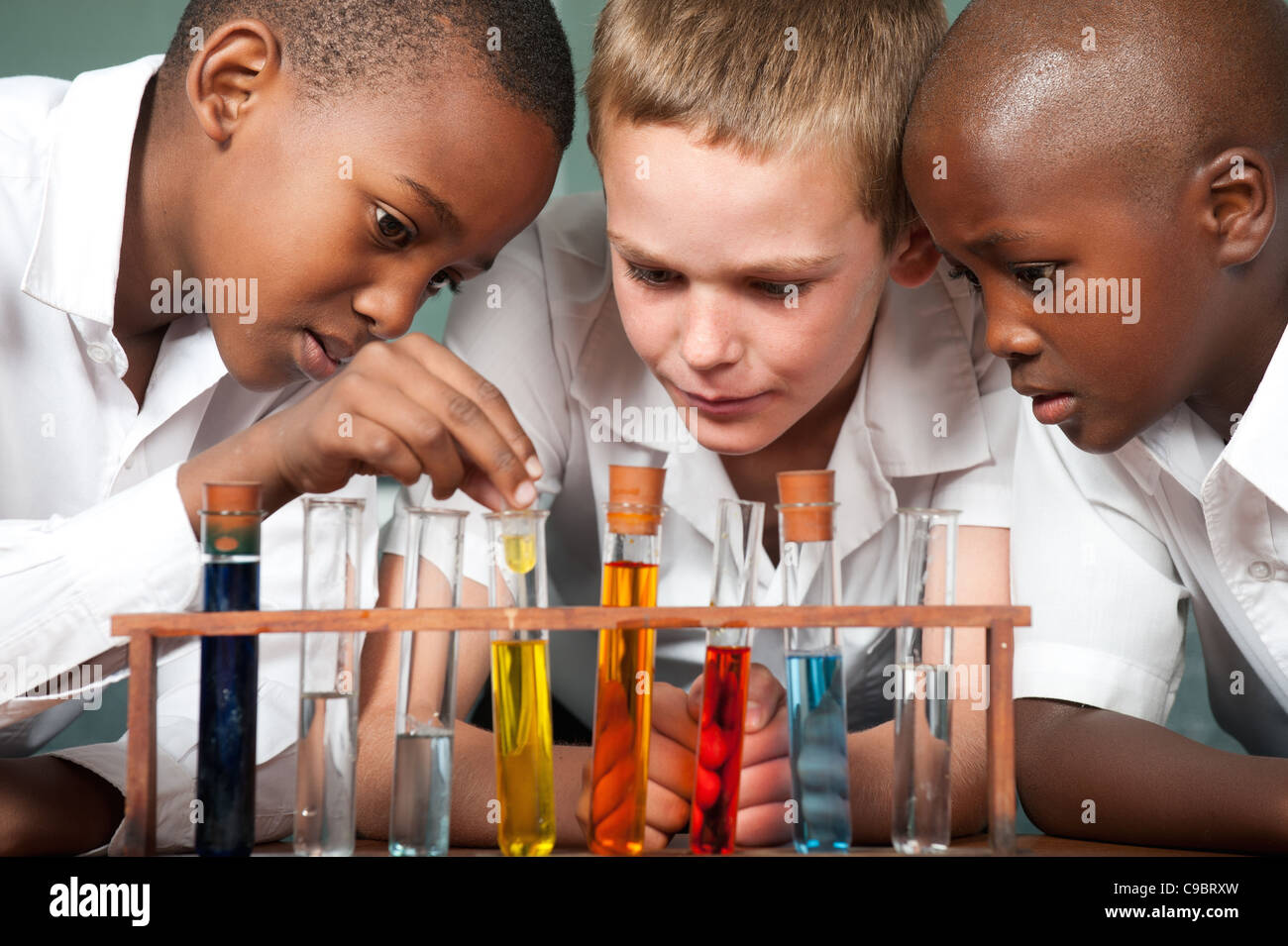 Drei jungen Blick auf Reagenzgläser im Klassenzimmer, Johannesburg, Provinz Gauteng, Südafrika Stockfoto