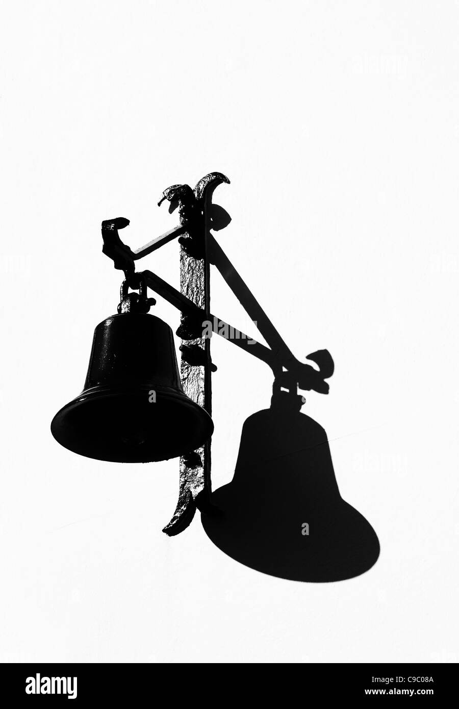 Schwarze Glocke und Halterung mit Schatten auf weißem Hintergrund Stockfoto