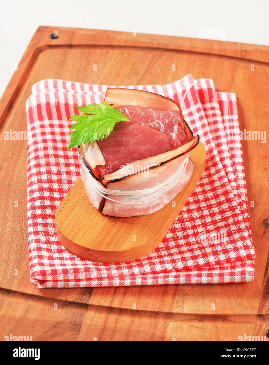 Rohe Schweinefilet in Scheiben Speck gewickelt Stockfoto