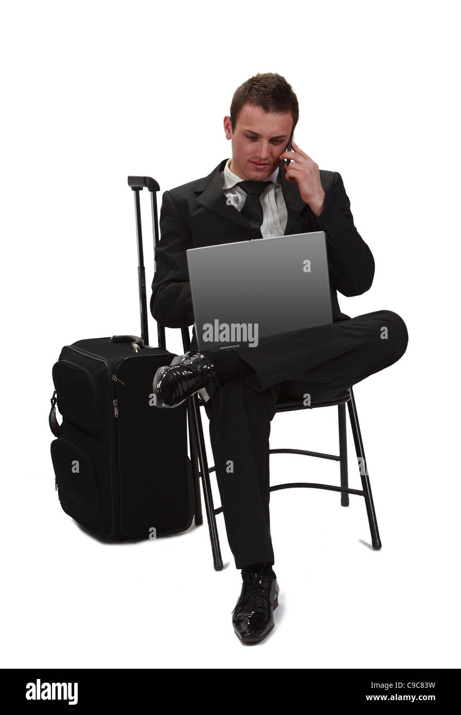 Jung und müden Reisenden Geschäftsmann arbeiten am Laptop beim per Telefon neben seinen Koffer ruft. Stockfoto