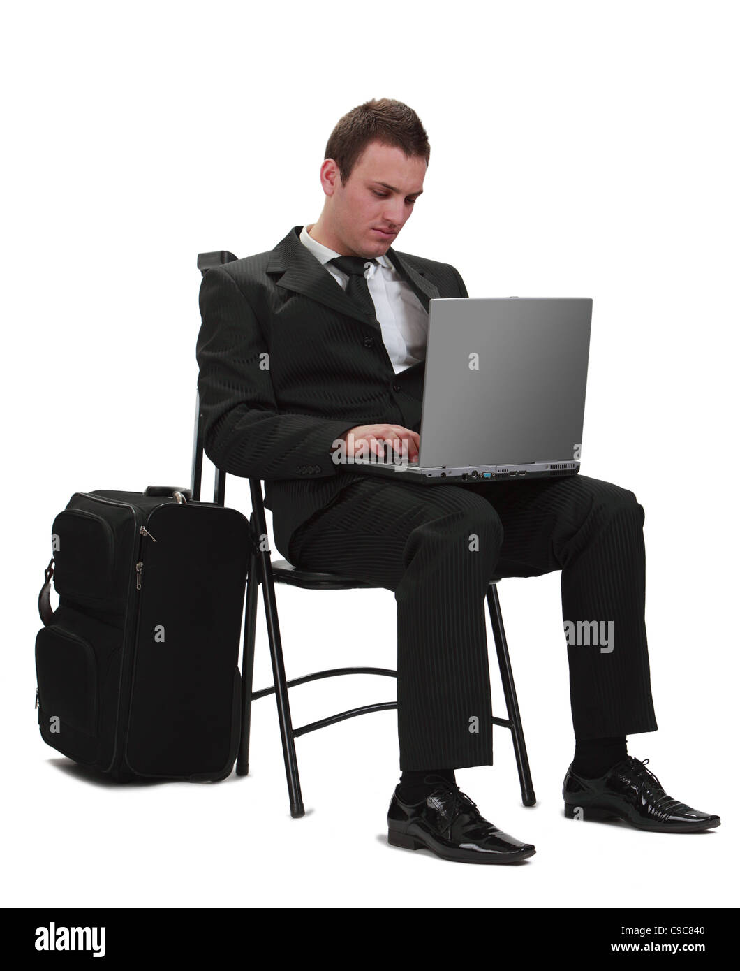 Jungen Reisenden Geschäftsmann arbeiten auf einem Laptop neben seinen Koffer. Stockfoto