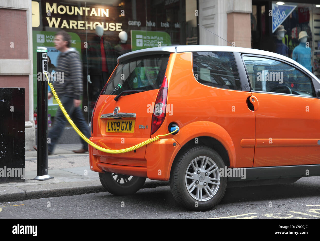 Eine kleine, orange Elektroauto verbunden zu einer Straße Laden Punkt, Covent Garden, London UK Stockfoto