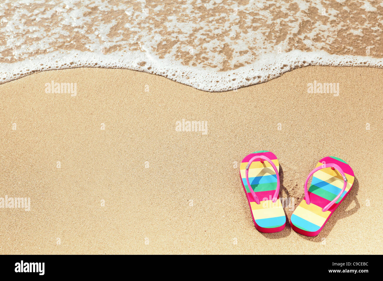Tropischer Urlaub Konzept--Flipflops auf einem sandigen Strand Stockfoto