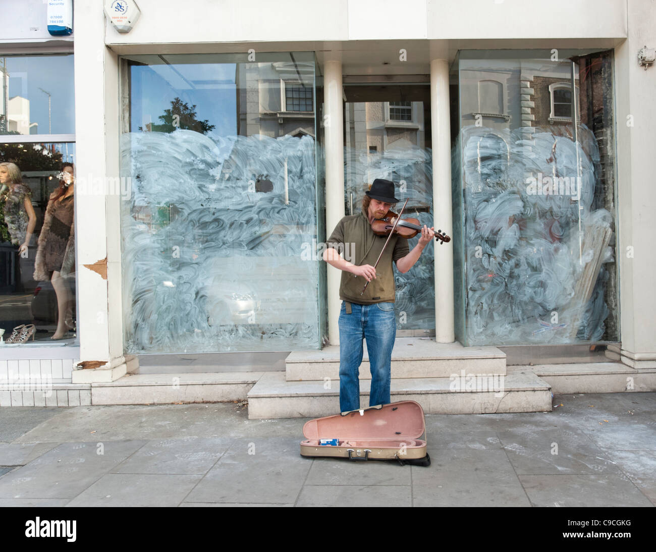 Busker Violine draußen spielen geschlossen Shop auf der King's Road, London, UK Stockfoto