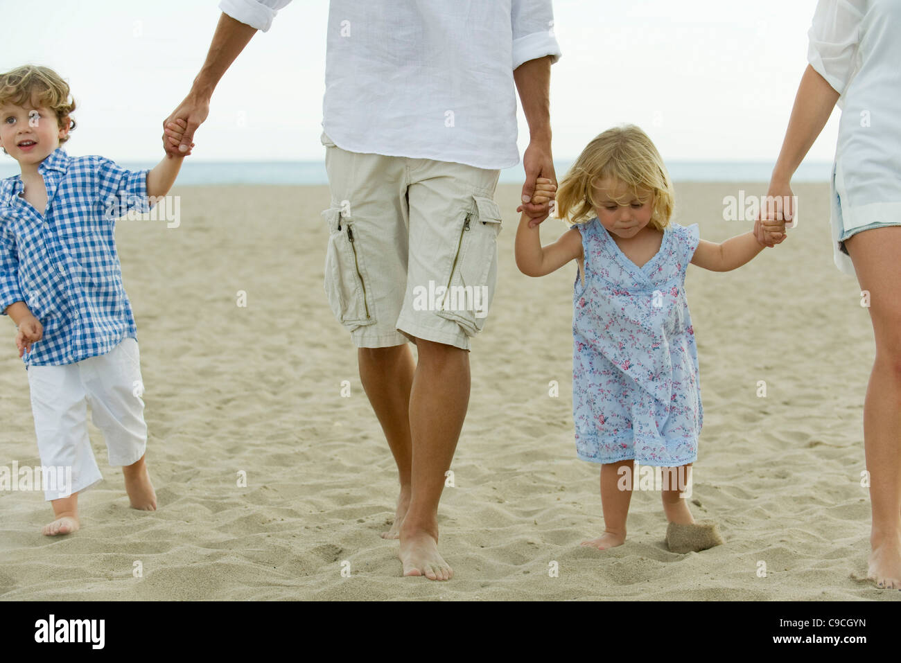 Familie hand in hand gehen, am Strand, beschnitten Stockfoto