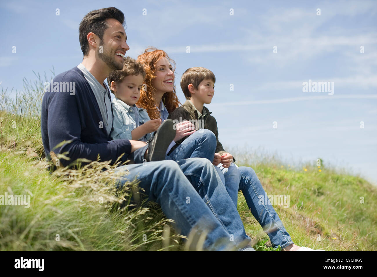 Eltern mit jungen sitzen auf der Wiese Stockfoto