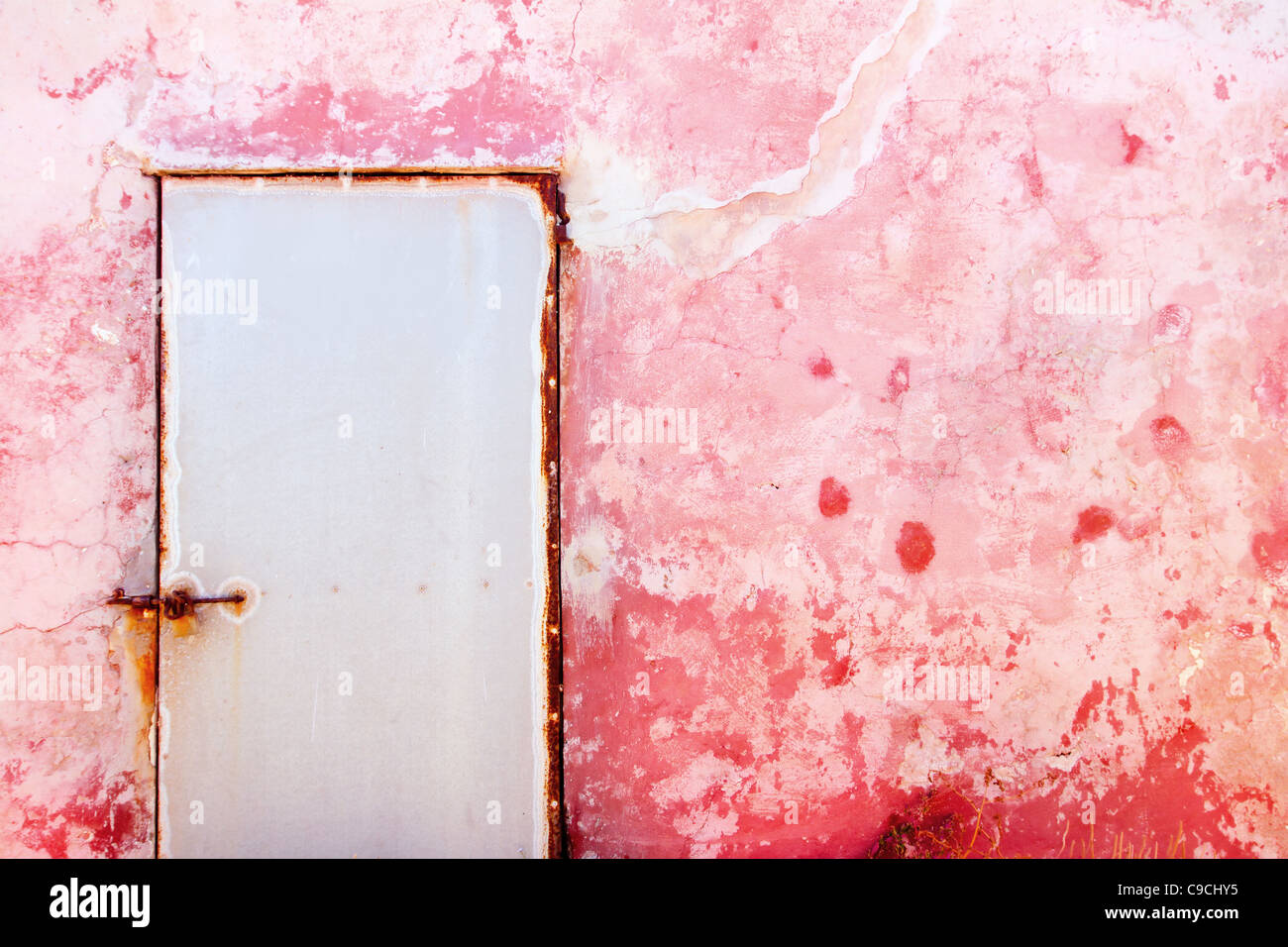 Rosa mediterrane Grunge Tür und Wand mit verwitterten Textur Stockfoto
