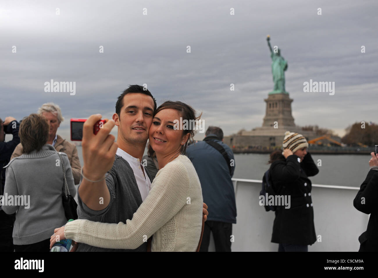 Touristen nehmen Foto der Statue of Liberty von einer Bootsfahrt Manhattan New York NYC USA Amerika Stockfoto