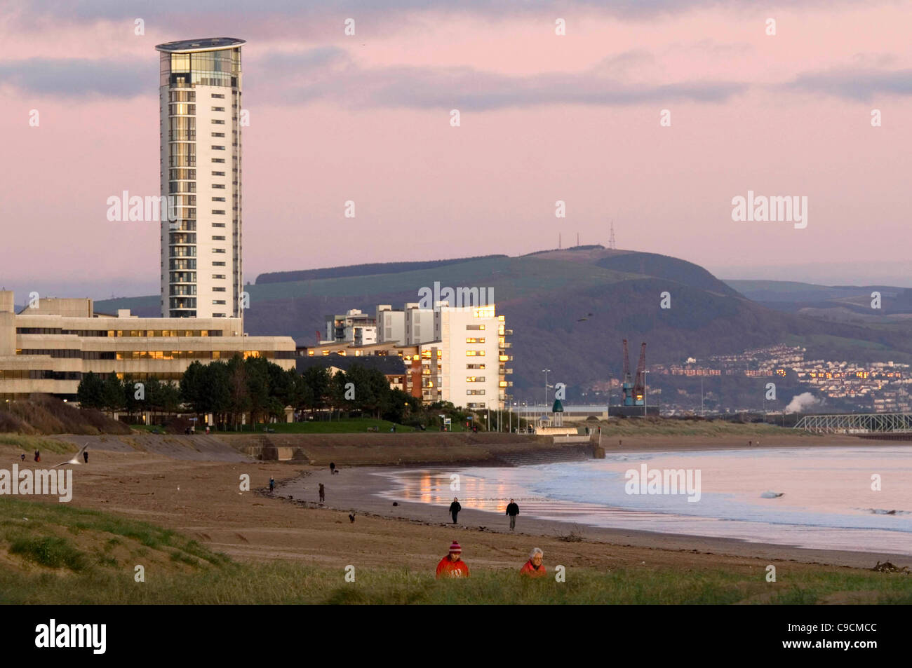 Wanderer nutzen die Abendsonne auf Swansea Bay in Süd-Wales auf eine knackige Herbst Nachmittag. Stockfoto