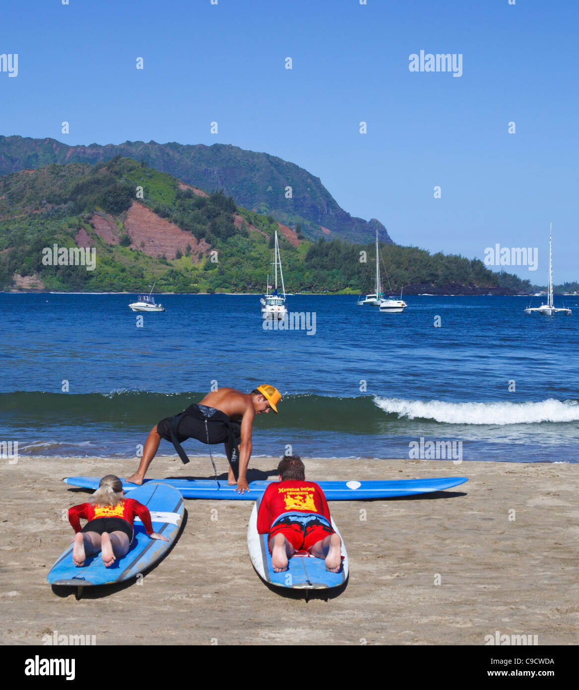 Surflehrer zeigt, bewegt sich in Hanalei Beach auf Kauai Stockfoto