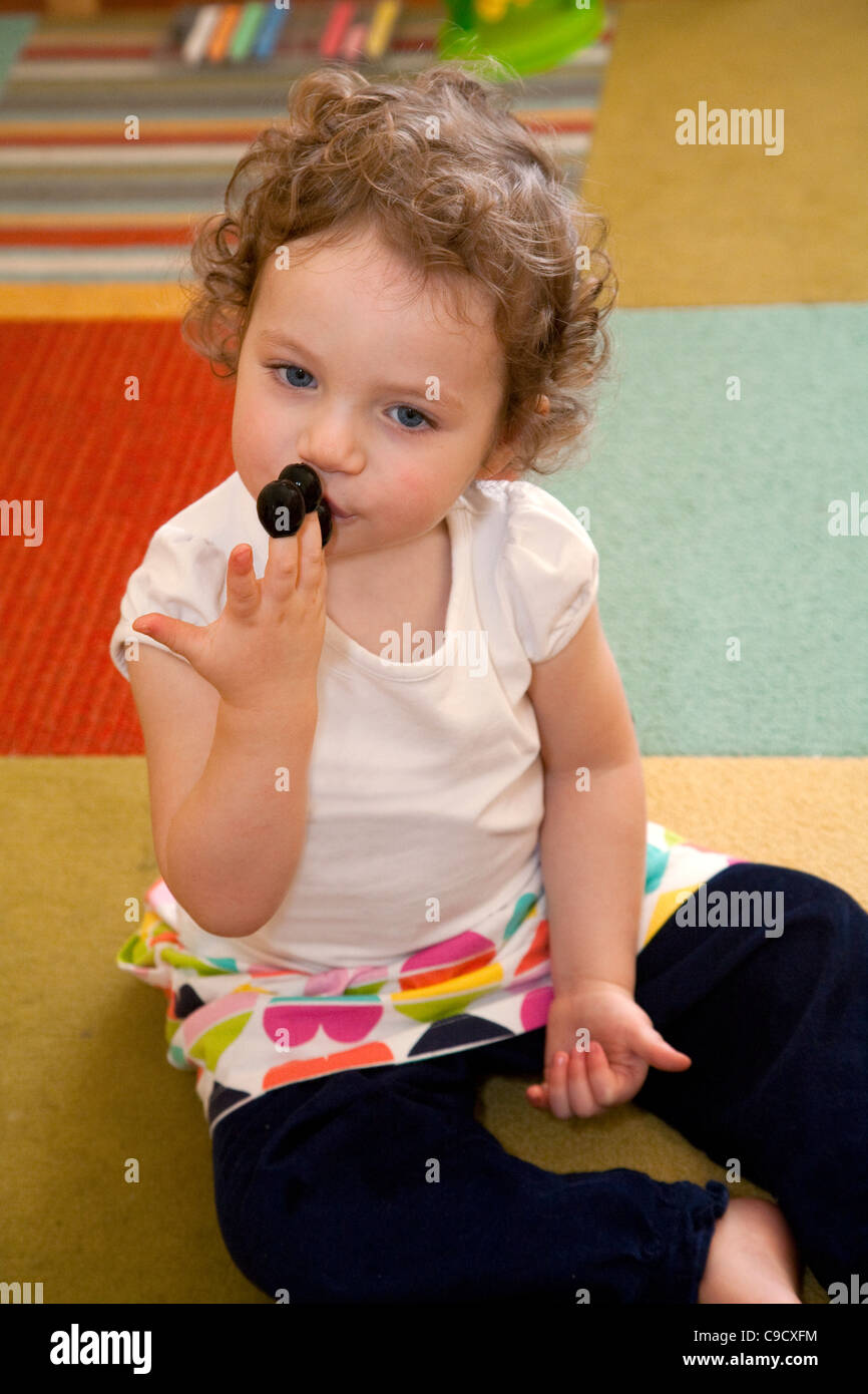 Kleine Mädchen schwarze Oliven aus den Fingern zu essen. Stockfoto