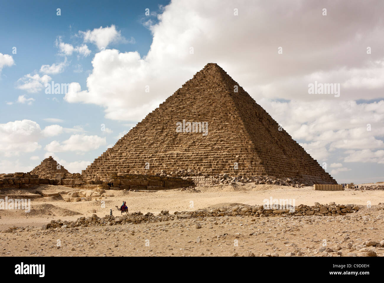 Die Pyramide von Khufu (große Pyramide oder Cheops) mit lückenhaft bewölktem Himmel mit einem Kamel im Vordergrund einige helle Wolke. Stockfoto
