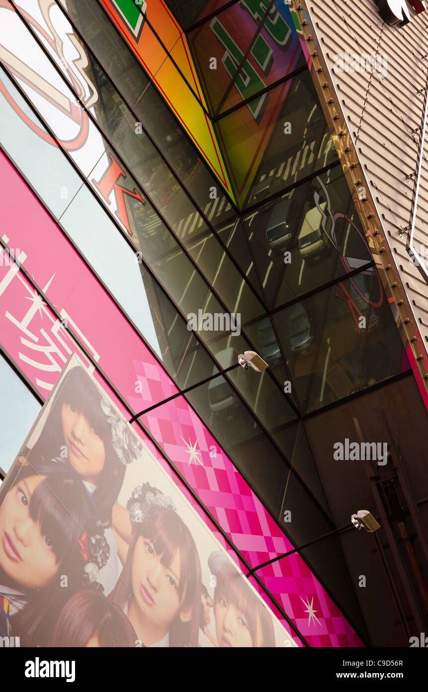 Japan, Tokyo, Akihabara Bezirk Frontmann Reflexion der verkehrsreichen Szene in AKB 48 Idol Glas Gebäude. Stockfoto