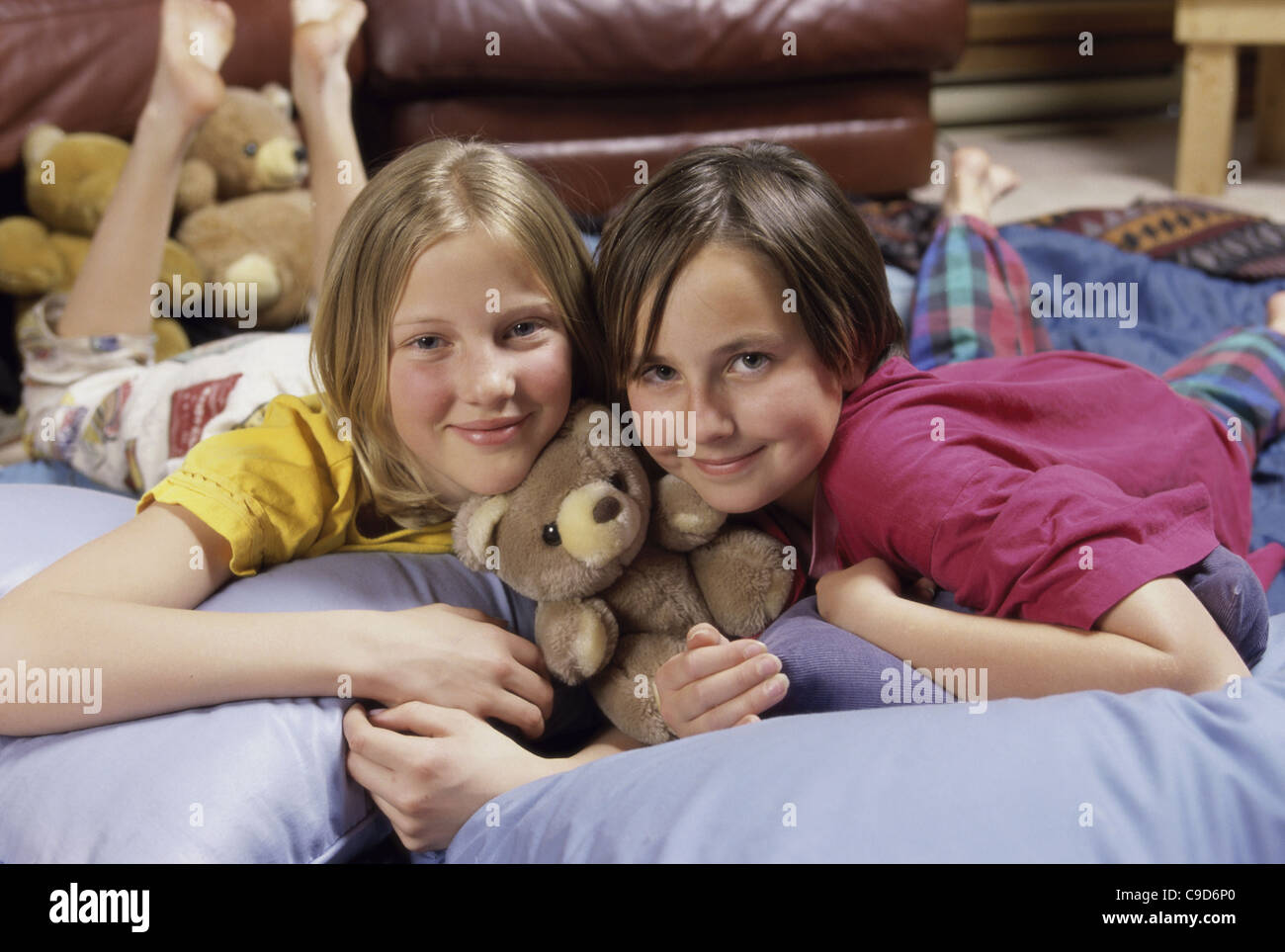 Porträt von zwei Mädchen, die auf einem Bett liegend Stockfoto