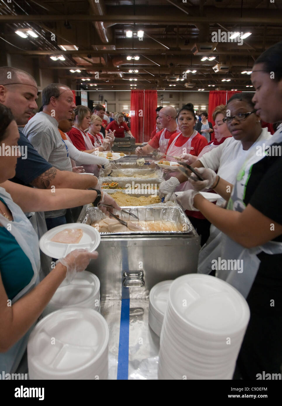 Multi-ethnischen Gruppe von freiwilligen Hilfe dienen Hunderte von Thanksgiving Mahlzeiten gestiftet von großen Texas basierte Supermarktkette. Stockfoto