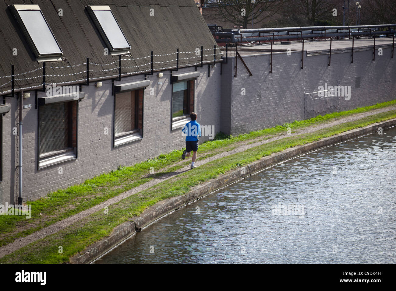 Jogger verläuft entlang der Leinpfad des Grand Union Canal in Loughborough. Stockfoto