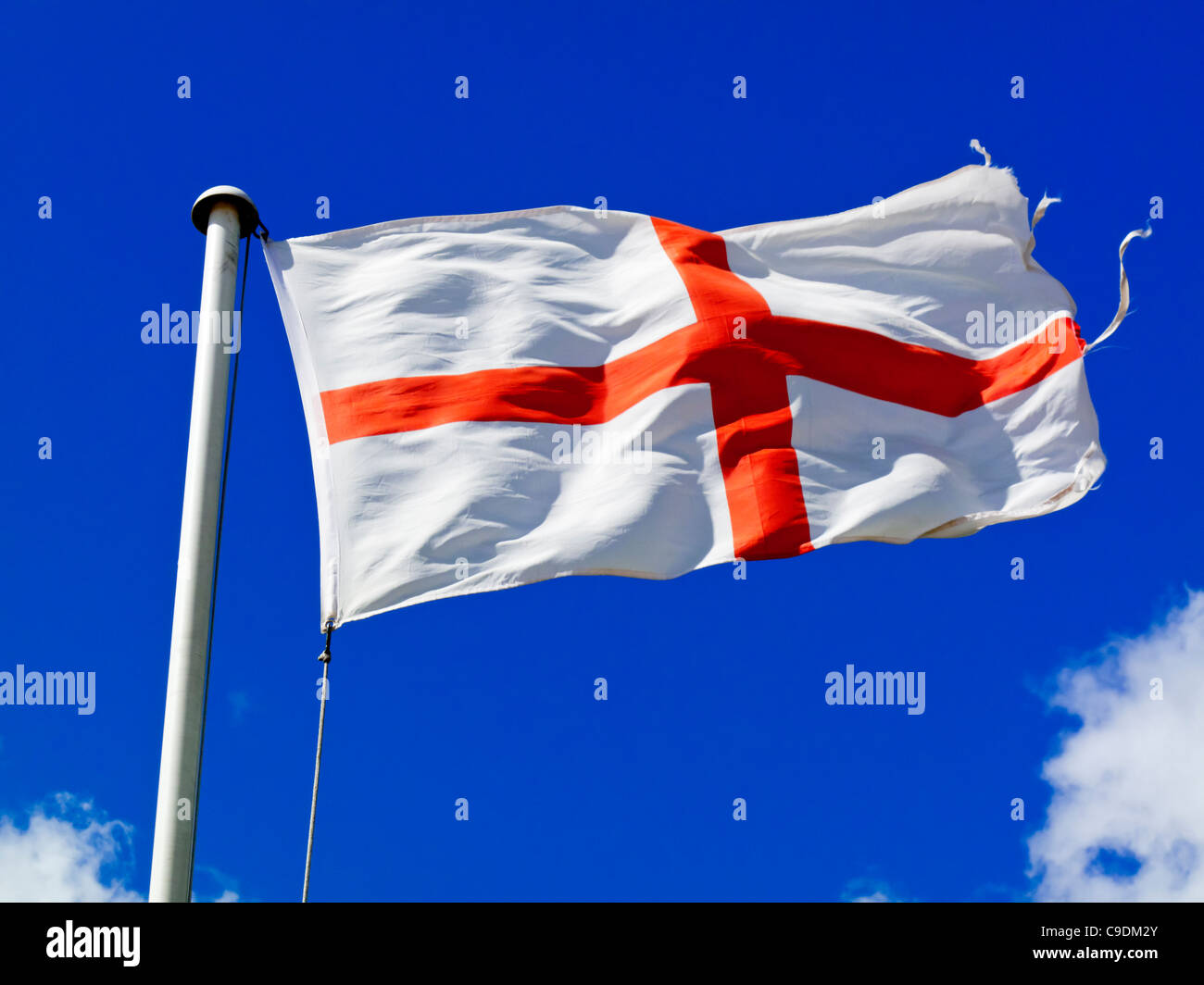 Englische Flagge, bekannt als St.-Georgs-Kreuz mit blauem Himmel hinter fliegen auch Wappen Most Noble Order of the Garter stellt Stockfoto