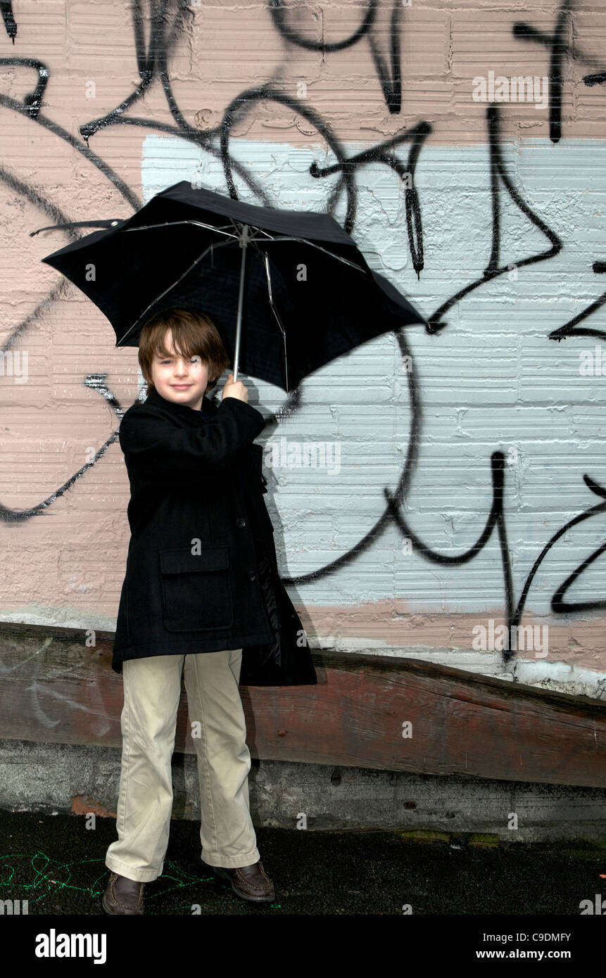 Junge mit Schirm in der Stadt Stockfoto