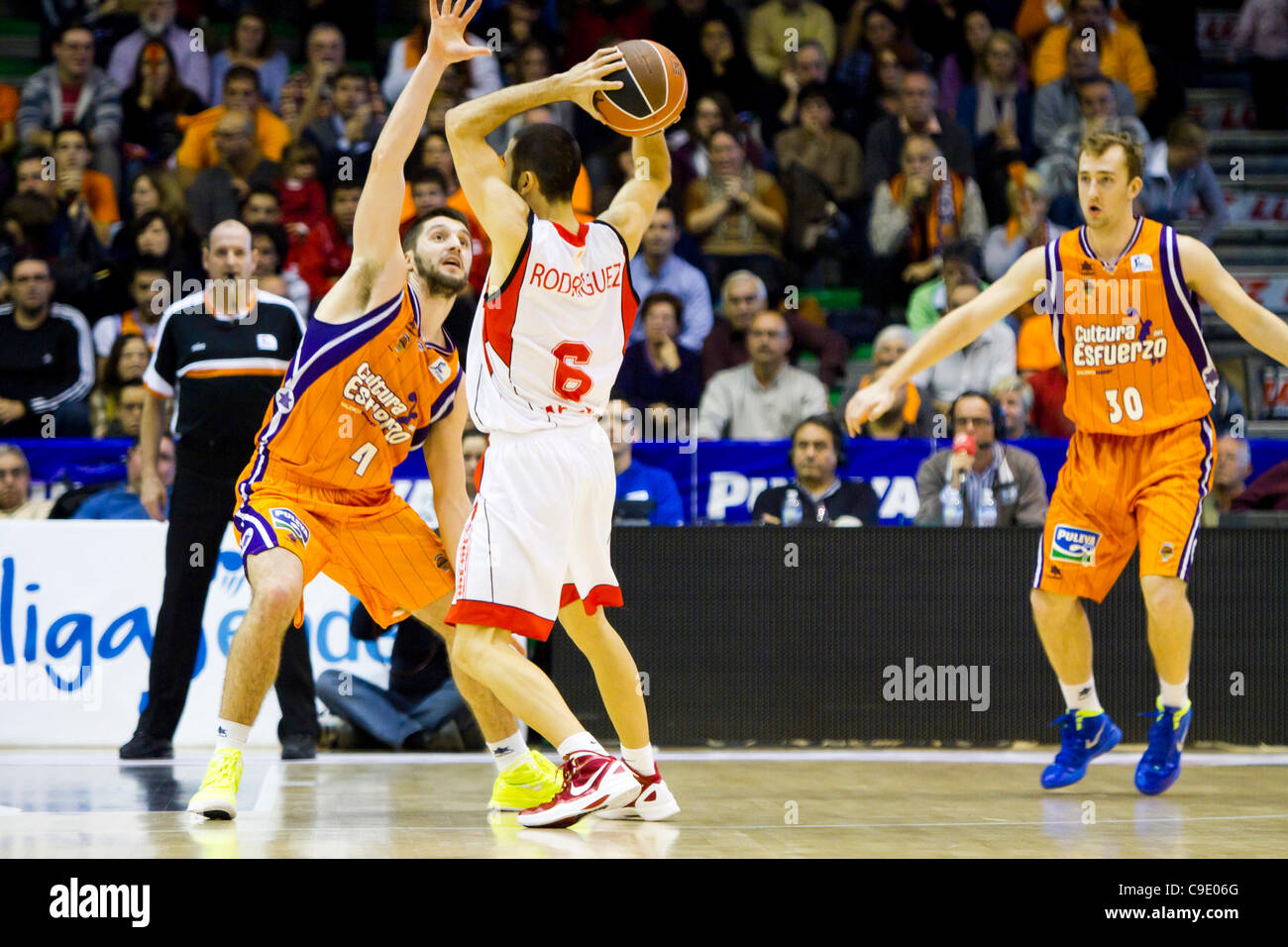 26.11.2011. Valencia, Spanien Basketball-match zwischen Valencia Basket Club und Assignia Manresa, Spieltag 9, Liga Endesa - Spanien---Javi Rodríguez aus Assignia Manresa bereitet seinen Pass mit der Opposition von Stefan Markovic aus Valencia Basket Club, während Gteam Kumpel Rishard Kuksiks Beobachter Stockfoto