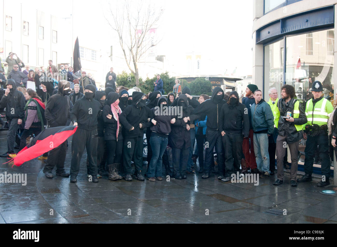 Brighton, UK. 30. November 2011. Anarchisten veer Weg von der vereinbarten Route während des öffentlichen Sektors Streik Marsches in Brighton, aggressiv gegenüber Journalisten und Versuch, aber ausfallen, zum Sturm der Churchill Square Shopping Mall, bevor durch die Polizei zurückgedrängt. Stockfoto