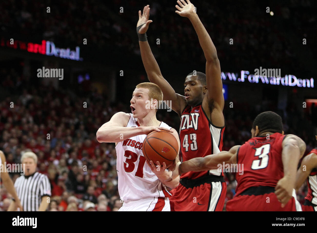 10. Dezember 2011 - Madison, Wisconsin, USA - teilt Wisconsin vorwärts Mike Bruesewitz #31 zwei UNLV Verteidiger auf dem Weg in den Korb für eine Punktzahl. Wisconsin Badgers besiegte der UNLV Rebels 62-51 im Kohl Center in Madison, Wisconsin. (Kredit-Bild: © John Fisher/Southcreek/ZUMAPRESS.com) Stockfoto