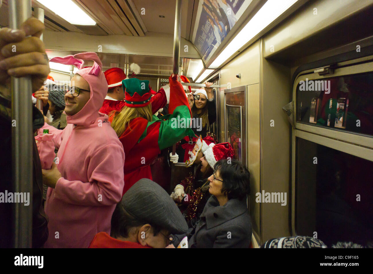 Weihnachten Nachtschwärmer Teilnahme an der jährlichen Santacon fahren mit der u-Bahn in New York auf Samstag, 10. Dezember 2011. Santacon, in erster Linie eine Kneipentour in Santa und andere Weihnachten Kostüme (bis auf einen Teilnehmer, der seinen Urlaub verwechselt habe), zieht Hunderte von Masken gehen im Zusammenhang Stockfoto
