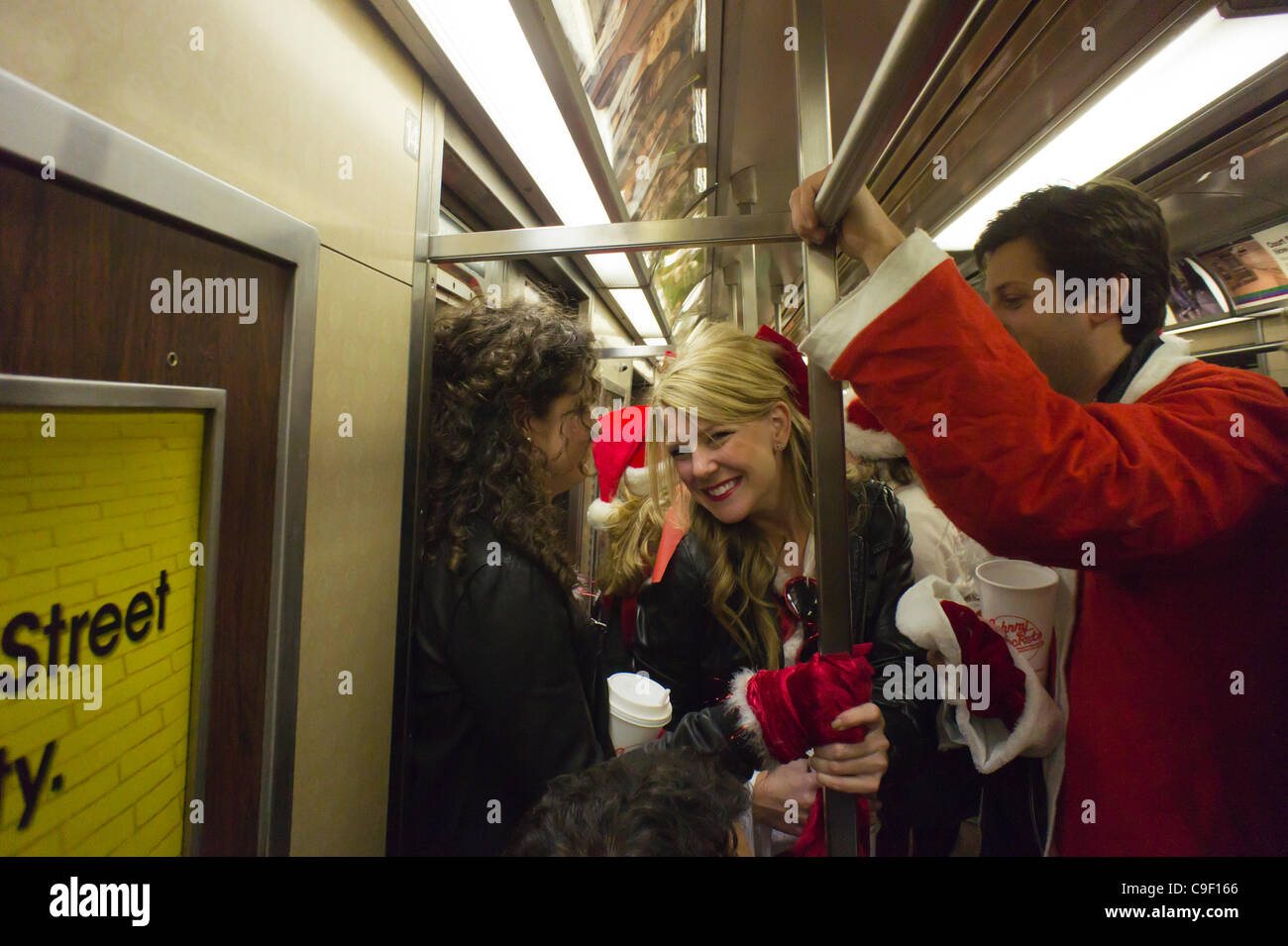 Weihnachten Nachtschwärmer Teilnahme an der jährlichen Santacon fahren mit der u-Bahn in New York auf Samstag, 10. Dezember 2011. Santacon, in erster Linie eine Kneipentour in Santa und andere Weihnachten im Zusammenhang mit Kostümen, zieht Hunderte von Masken gehen von Bar zu Bar. Der Trinker wurden ermutigt, trinken bei e Stockfoto
