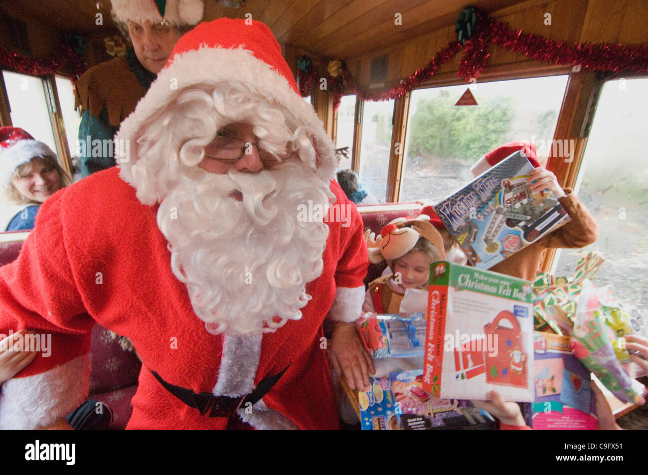 Der Weihnachtsmann und seine Elfen unterhalten und Geschenke für Kinder an Bord der Welsh Highland Railway in Snowdonia North Wales.on 17 Dezember 2011 Stockfoto