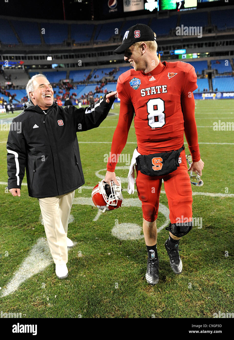 27.Dec 2011 - Charlotte, North Carolina; USA - North Carolina State Wolfpack Quarterback (8) MIKE GLENNON akzeptiert die MVP-Auszeichnung wie der North Carolina State Wolfpack konkurrieren gegen die University of Louisville Cardinals in der Belk Schüssel College-Football-Spiel, das bei der Bank of America stattfand Stockfoto