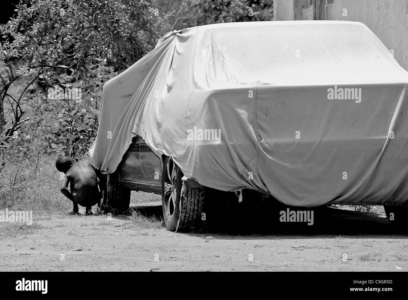 29. September 2010 - uriniert Kano, KANO, NIGERIA - ein Kind neben einem Auto auf Tori-Home-Reha-Zentrum in der Nähe von Kano, Nigeria.  Es gibt keine Toiletten in der Schule. Wilden Polio wächst in Wasser durch ungeklärte Abwässer verunreinigt und breitet sich durch mangelnde Hygiene... Religiöser Fanatismus und Fehlinformationen haben Stockfoto