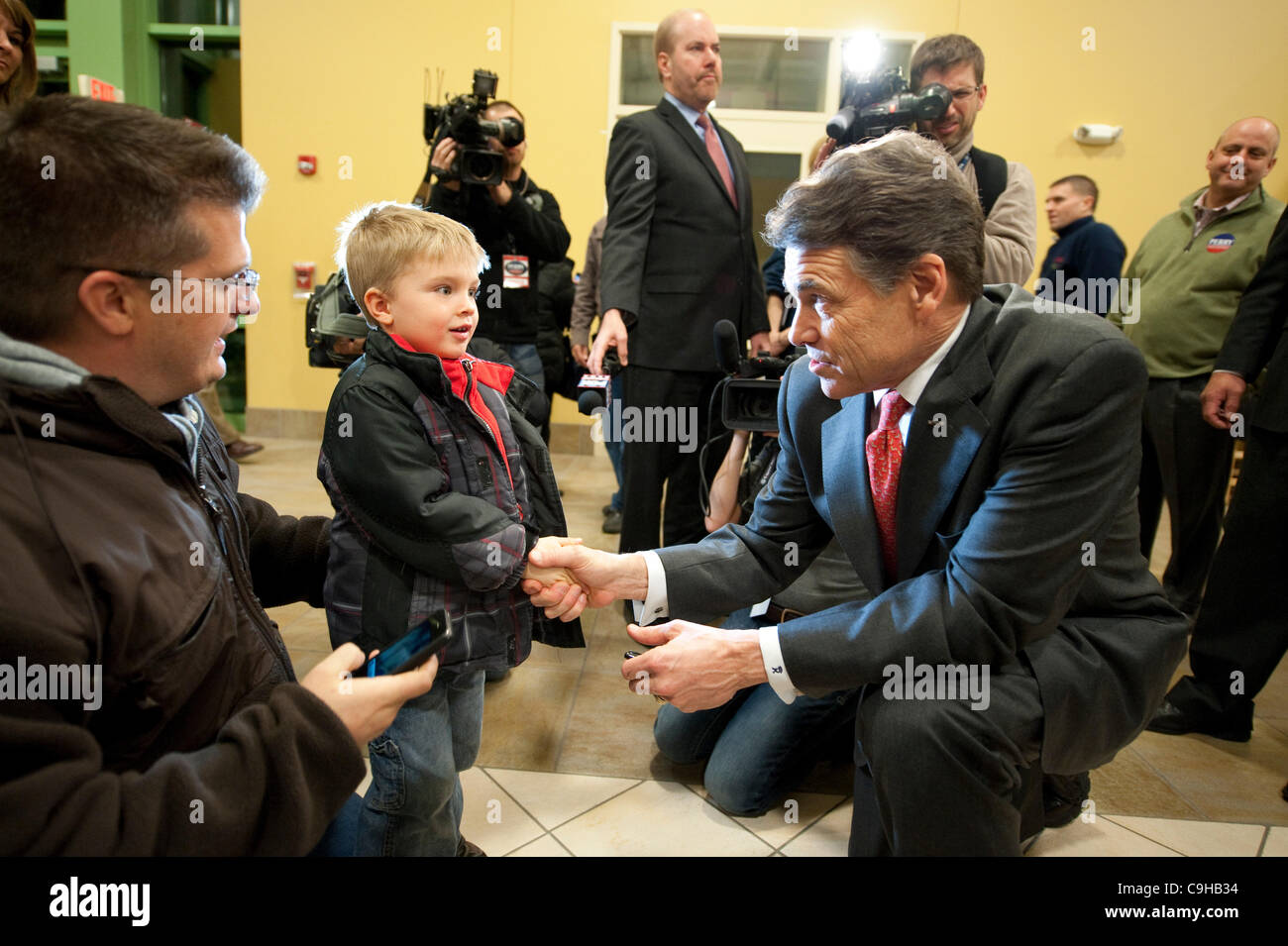 Kandidat der republikanischen Präsidentschaftskandidaten Rick Perry grüßt einen kleiner Junge vor anlässlich einer Veranstaltung Caucus in Iowa. Stockfoto