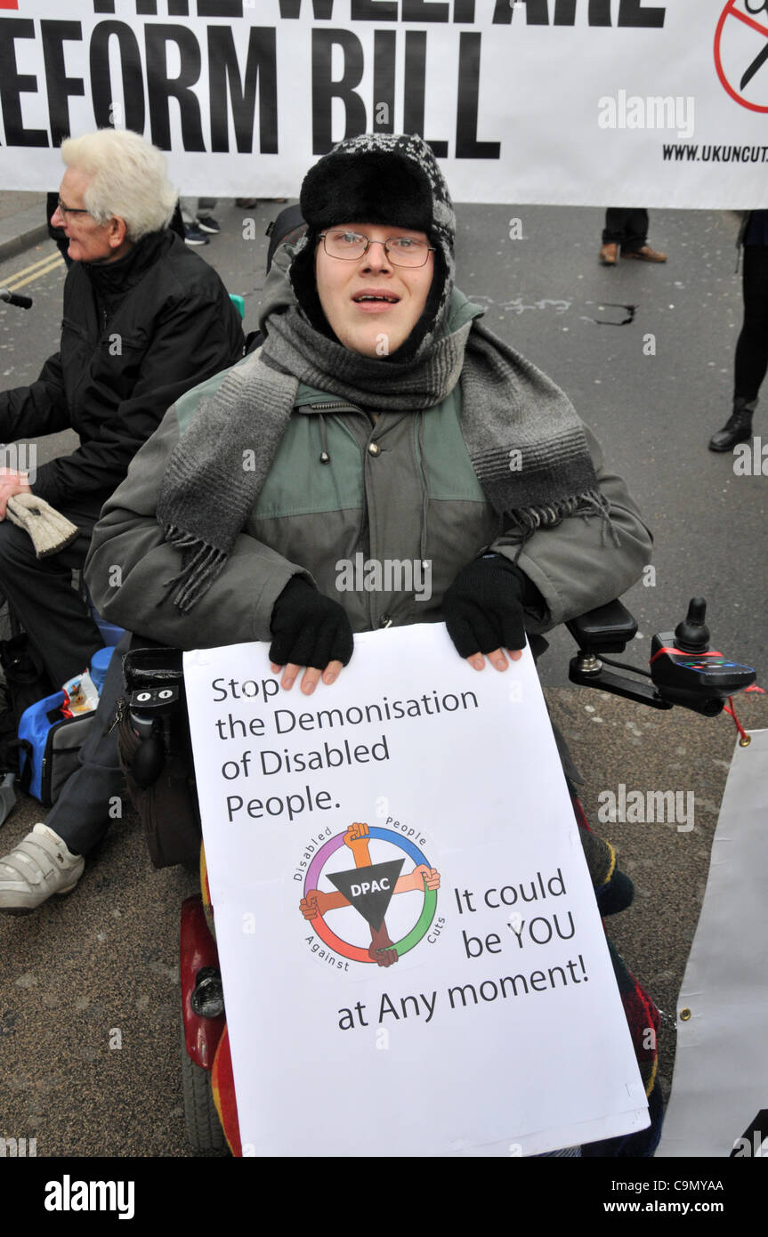 Demonstranten gegen die Welfare Reform Bill blockieren Oxford Circus Sonntag, 28. Januar 12.  Rollstuhlfahrer sind auf der anderen Straßenseite außerhalb Niketown miteinander verkettet. Stockfoto